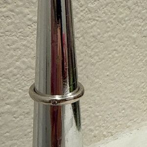 This is a Tiffany & Co. Elsa Peretti band ring in silver with a single round b